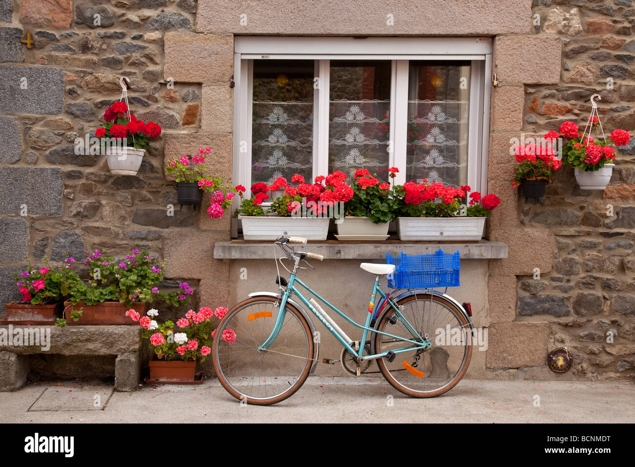 Fahrrad und bunten Blumenkästen in einer Seitenstraße in St. Quay Portrieux, Bretagne, Frankreich Stockfoto