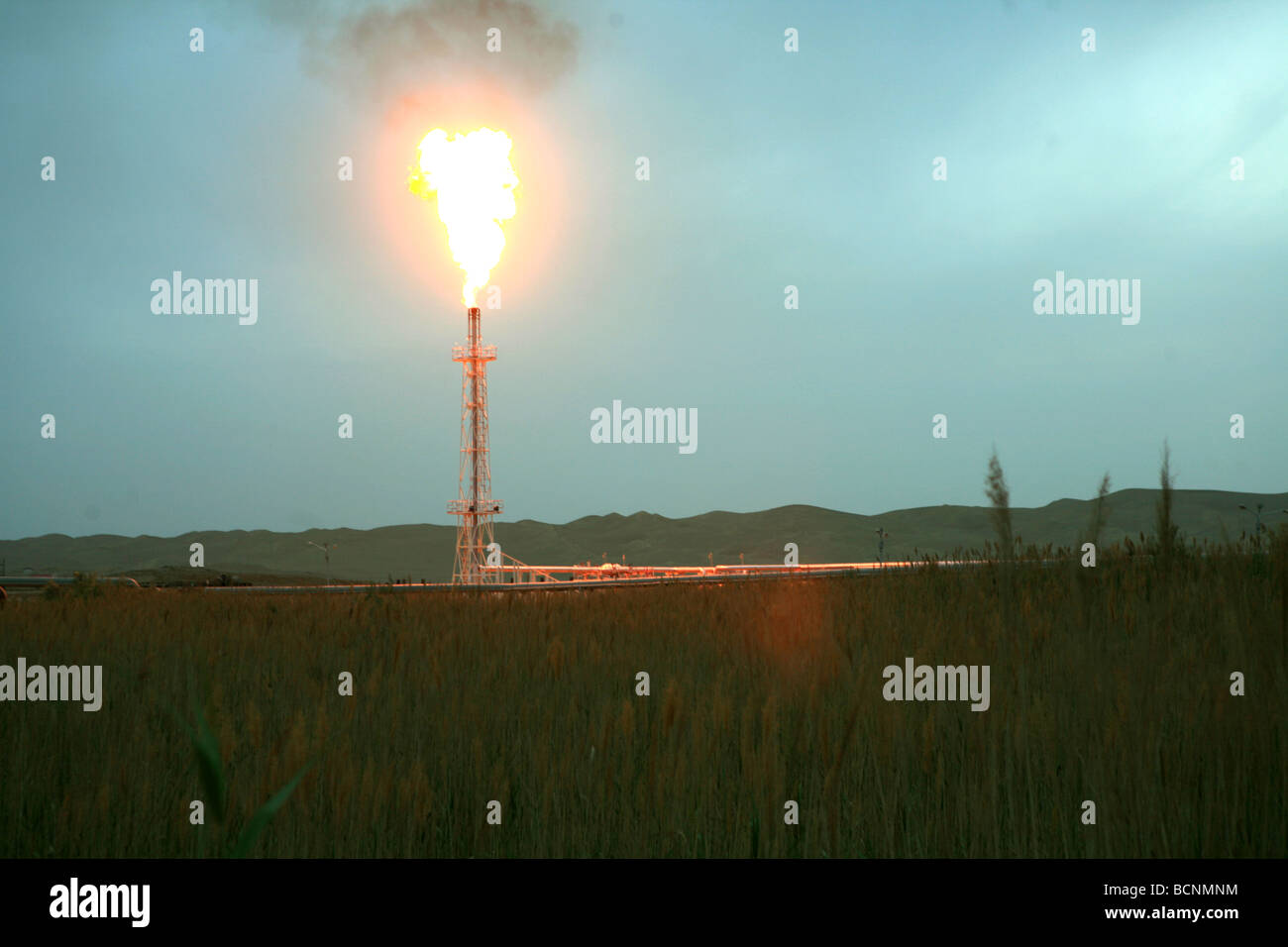 Flammen Sie schießen heraus aus einer Ölquelle, Uigurischen Autonomen Gebiet Xinjiang, China Stockfoto