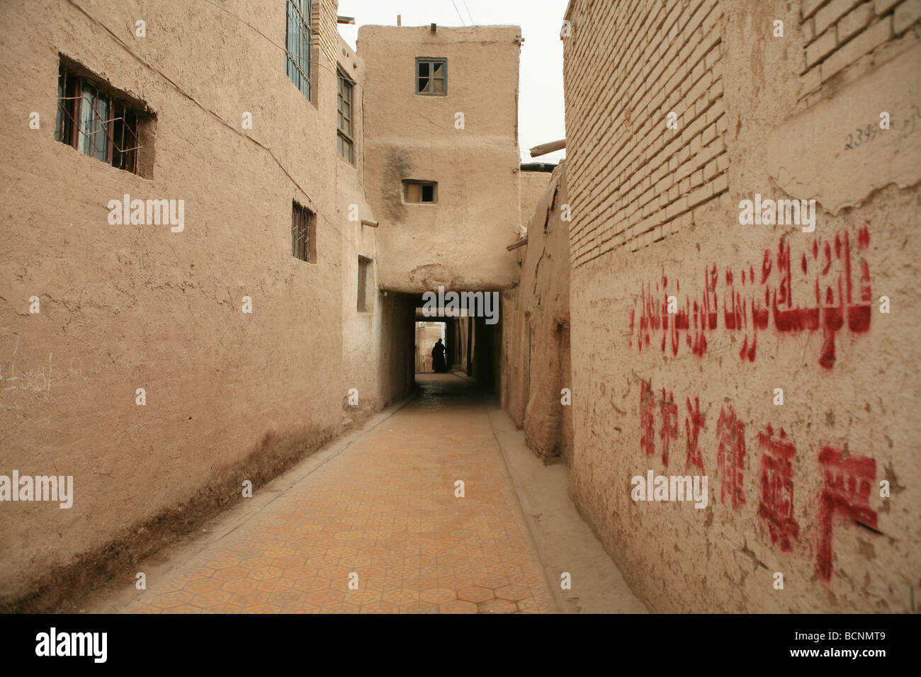 Schmale Gasse von typischen Uyghur Wohngebiet bestehend aus Schlamm Ziegel Häuser, Hotan, Uigurischen Autonomen Gebiet Xinjiang, China. Stockfoto