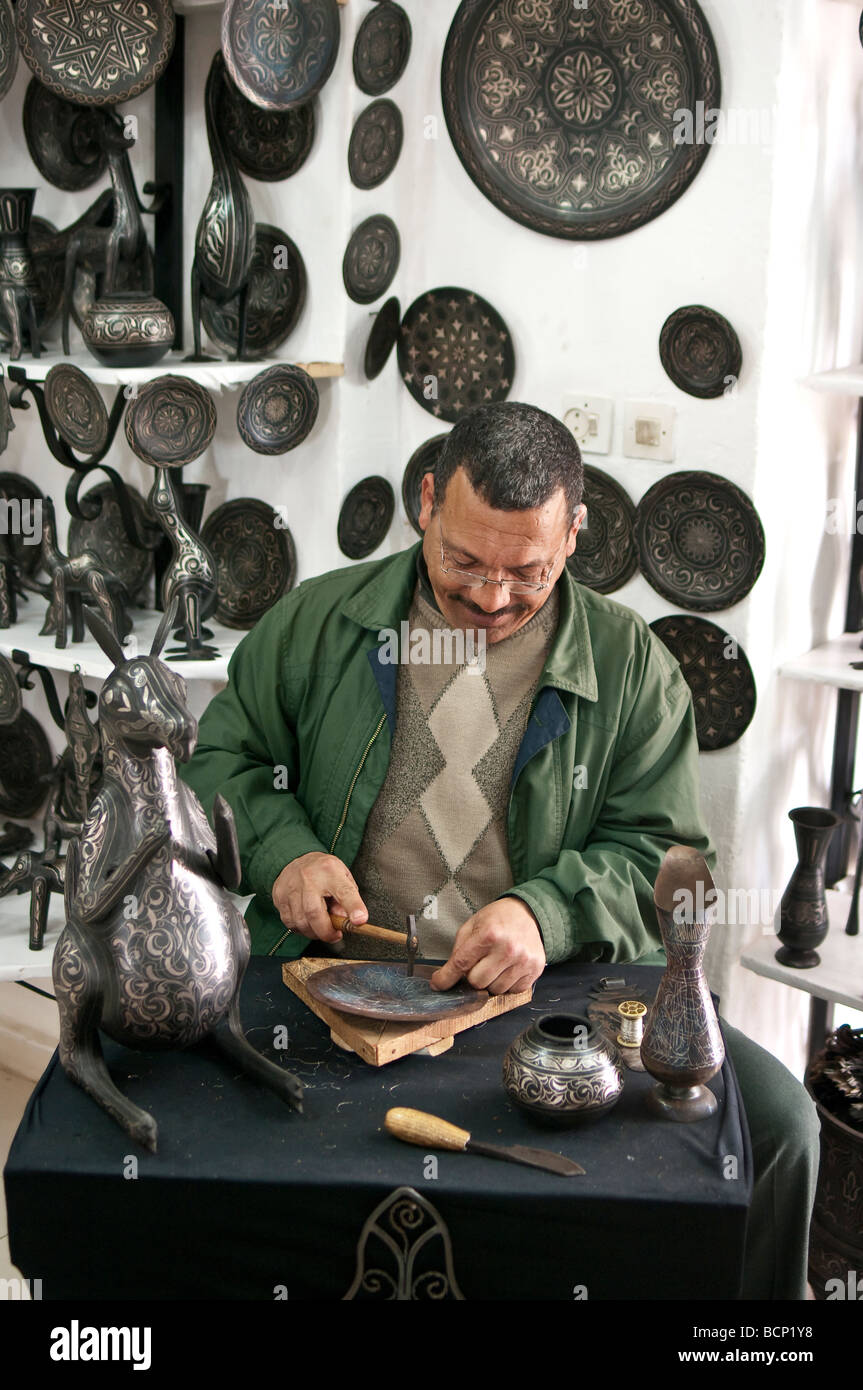 Arabische Handwerker dekorieren eine Platte mit silbernen mit Filigran geschmückten in Meknès, Marokko Stockfoto