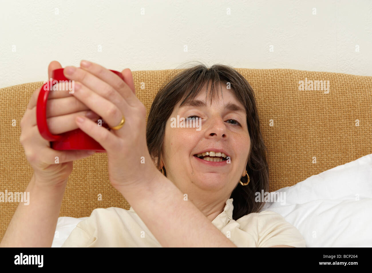 Frau im Bett heißes Getränk Tee Kaffee trinken Stockfoto