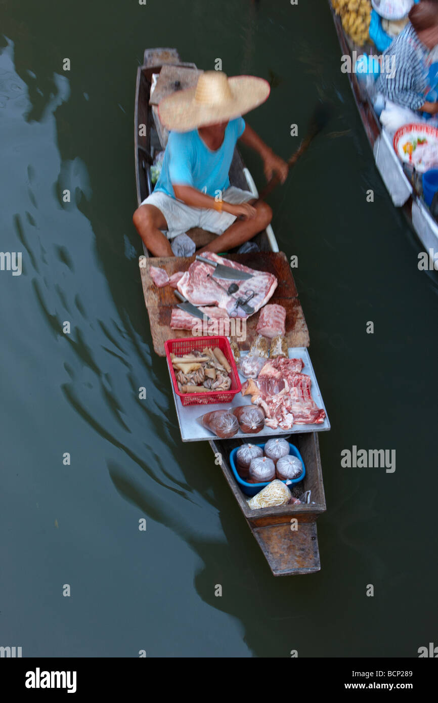 ein Mann, ein Boot paddeln lade mit frischem Fleisch auf dem schwimmenden Markt in Damnoen Saduak, nr Bangkok, Thailand Stockfoto
