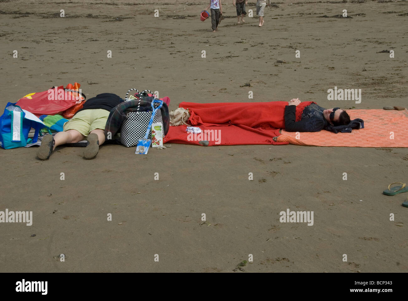 Pembrokeshire Wales Broadhaven Strand zwei Frauen unter einer Decke schlafen Stockfoto