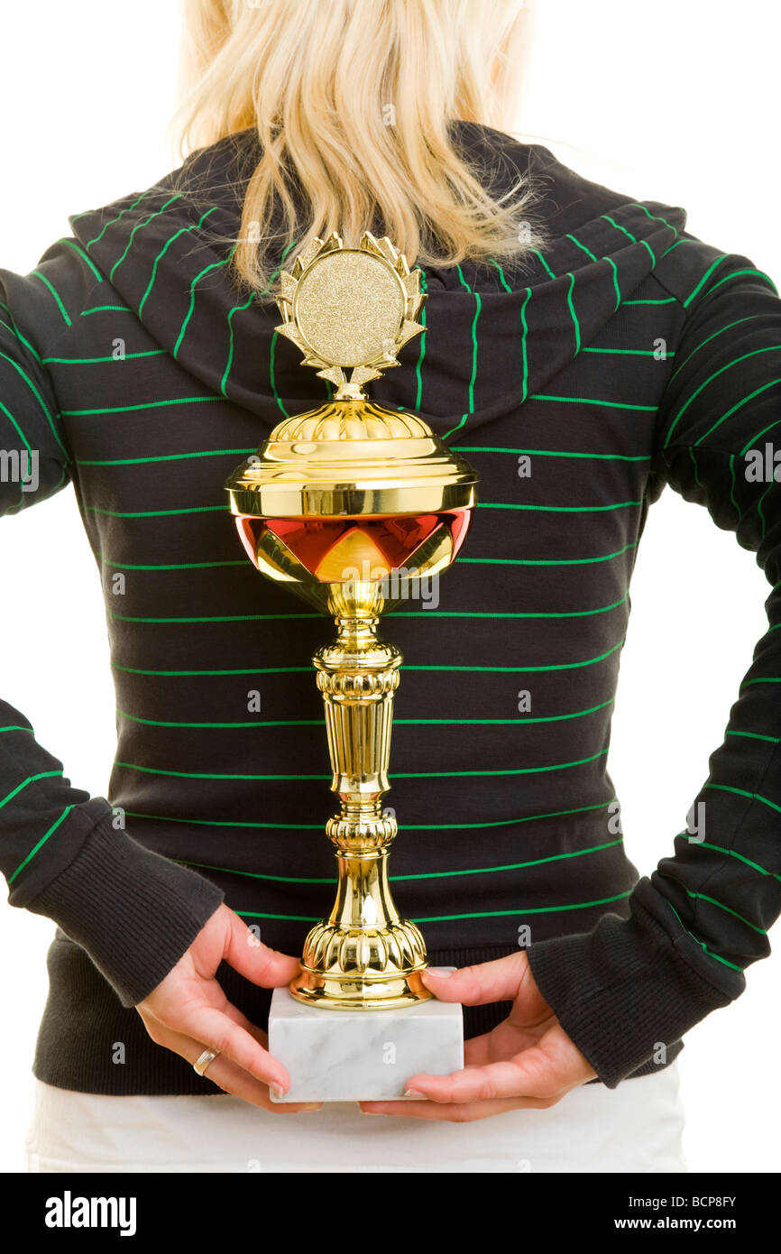 Junge Frau in Sportkleidung Hält Einen Pokal spielte Dachmarke Rücken versteckt Stockfoto