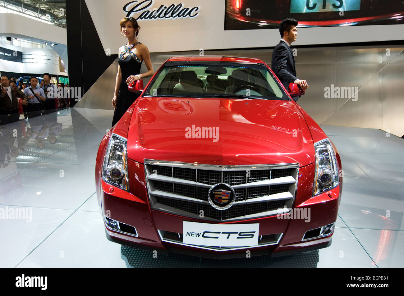 Asiatische Fahrzeugmodelle posiert neben einem roten Cadillac sport Auto, 2008 Beijing International Automotive Exhibition, Beijing, China Stockfoto