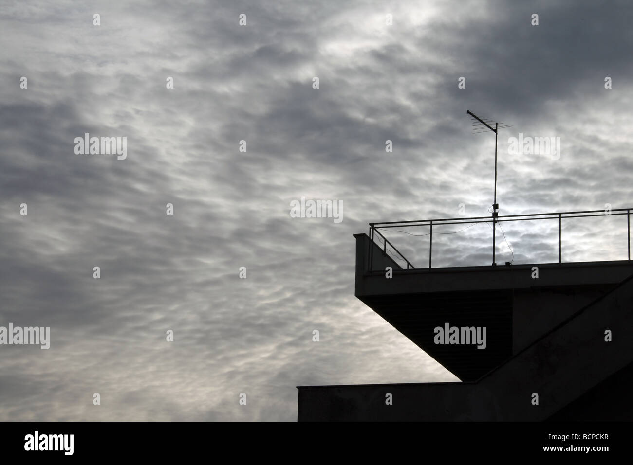 eine tv-Antenne auf Eigenschaft Dach gegen düstere Stimmung bewölktem Himmel Stockfoto