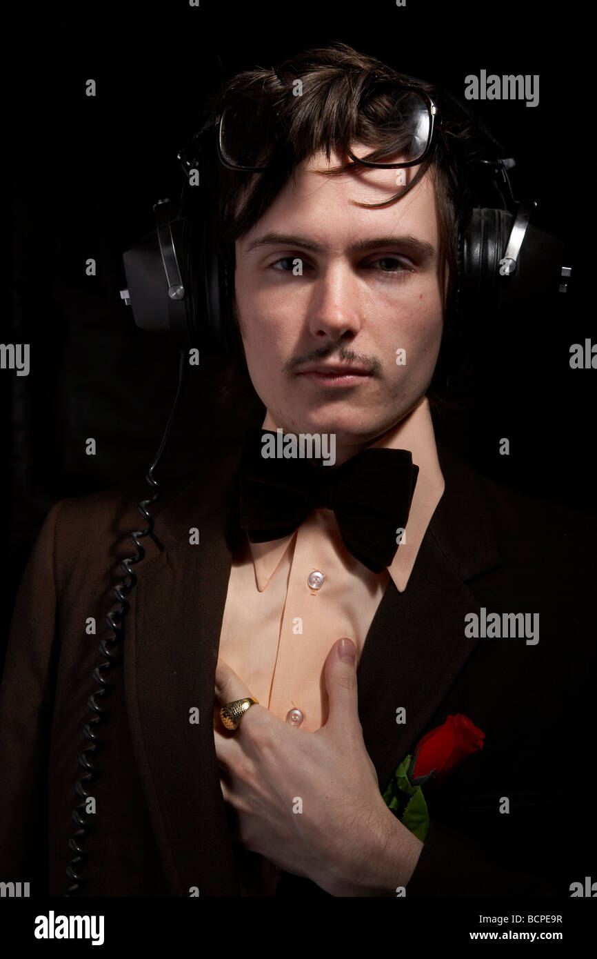 Porträt des Mannes mit 70er-Style-Outfit mit Datensätzen und Kopfhörer Stockfoto