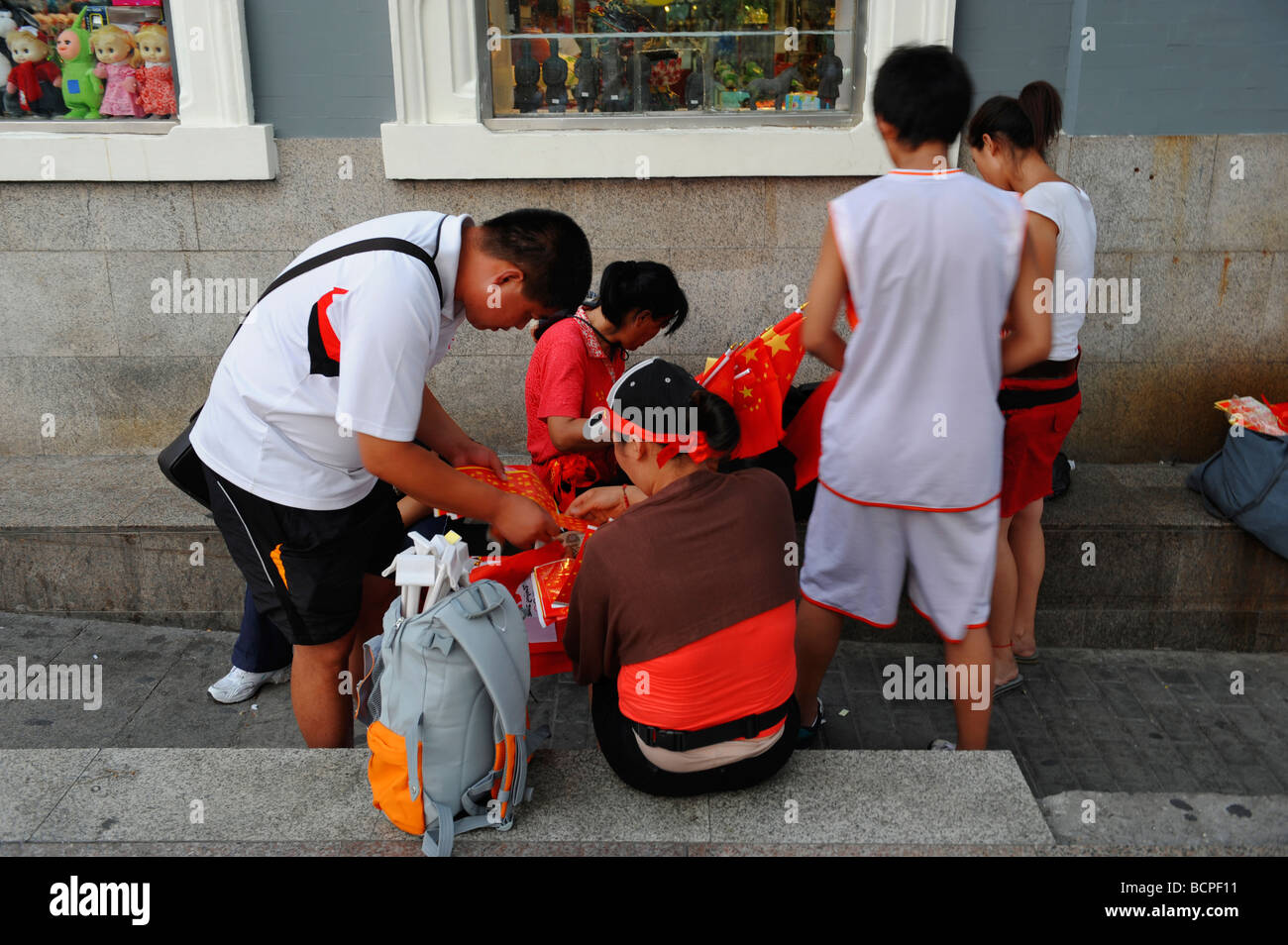 Chinesische Kinder Nationalflaggen auf der Straße zu verteilen, während 2008 Beijing Olympischen Spiele in Peking, China Stockfoto