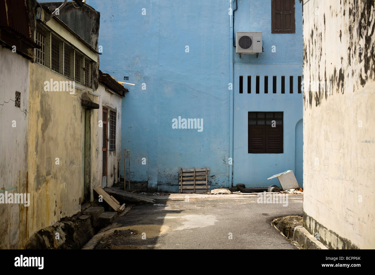 Ein Blick auf eine leere Gasse in Melacca, Malaysia mit einer blauen Wand Stockfoto