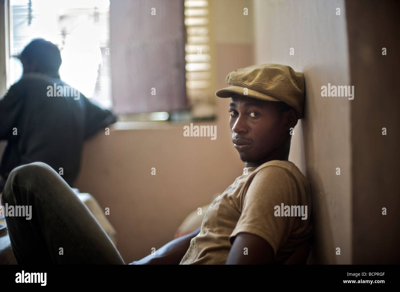 Ein junger Mann sitzt in einem familiären Restaurant in Cap Haitien, Haiti am 22. Juli 2008. Stockfoto