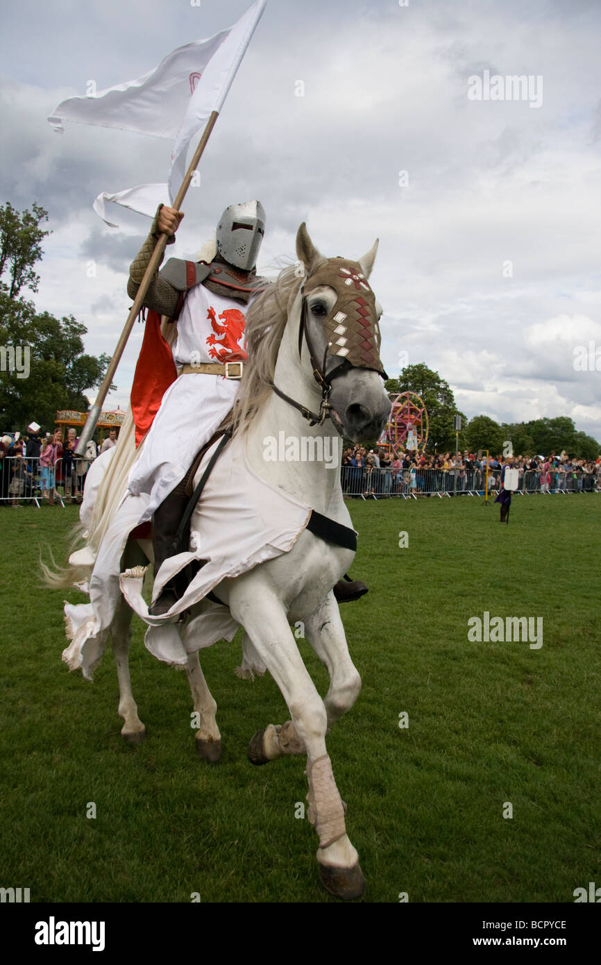 Mittelalterliche Ritter im Galopp auf dem Pferd hält den Standard empor im Triumph. Lambeth Country Show, London, England, 18. Juli 09 Stockfoto