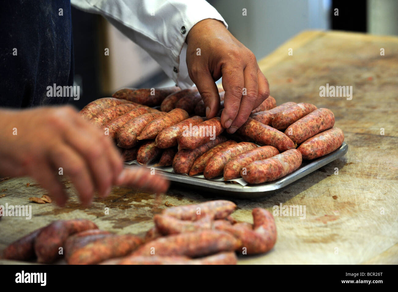 Ein Metzger sortiert aus hausgemachten Wurstwaren in Bramptons einem traditionellen Metzger in Kemp Stadt Brighton Stockfoto