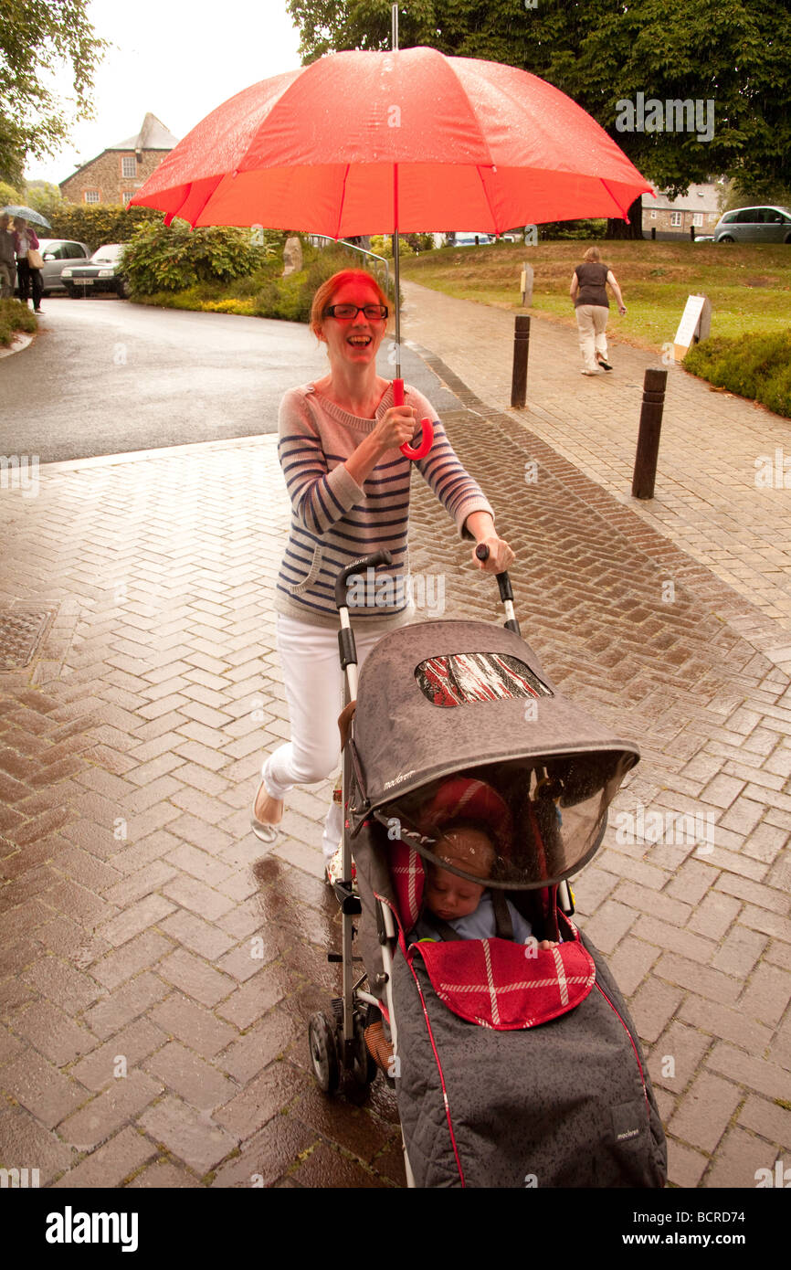 Mutter mit dem Kinderwagen in den Regen Devon England gefangen. Stockfoto