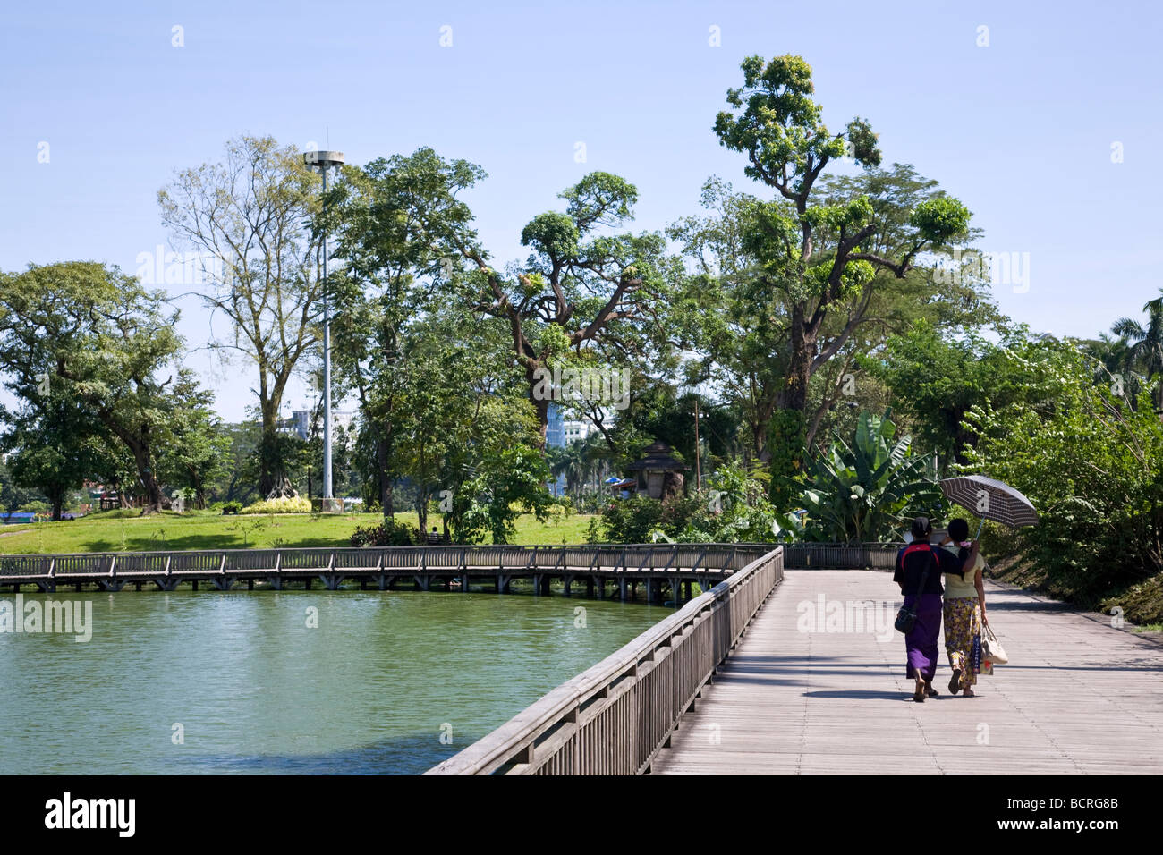 Burmesische paar zu Fuß über die Fußgängerbrücke. Kandawgyi See. Yangon. Myanmar Stockfoto
