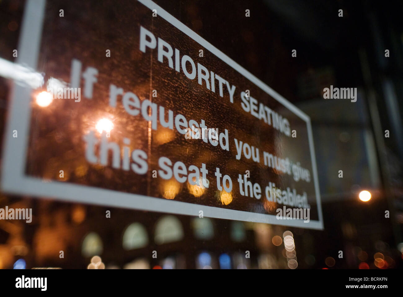Eine Priorität Sitzgelegenheiten Zeichen Sitzplatzreservierung für Menschen mit Behinderungen ist in einem New Yorker Bus gesehen. Stockfoto