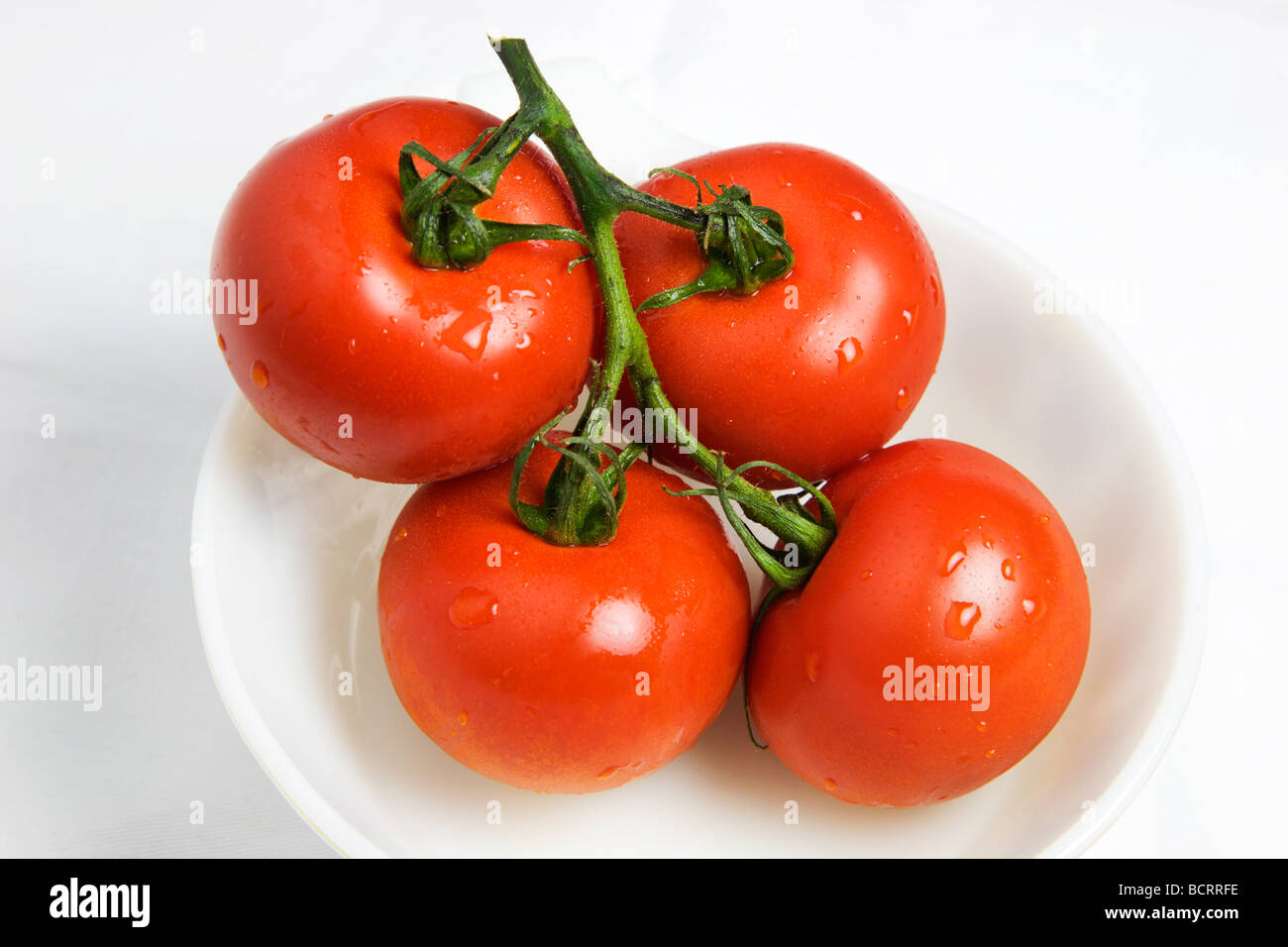 Rebe reife Tomaten in eine Schüssel weiß auf weißem Hintergrund Stockfoto