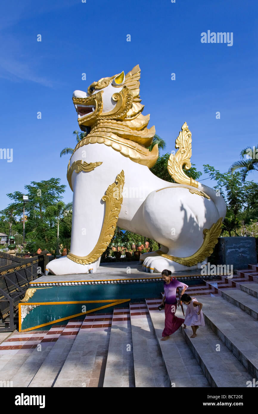 Burmesische Mutter und Tochter. Chinthe Wächter (halb Löwe, halb Drache). Ngahtatgyi Paya. Yangon. Myanmar Stockfoto