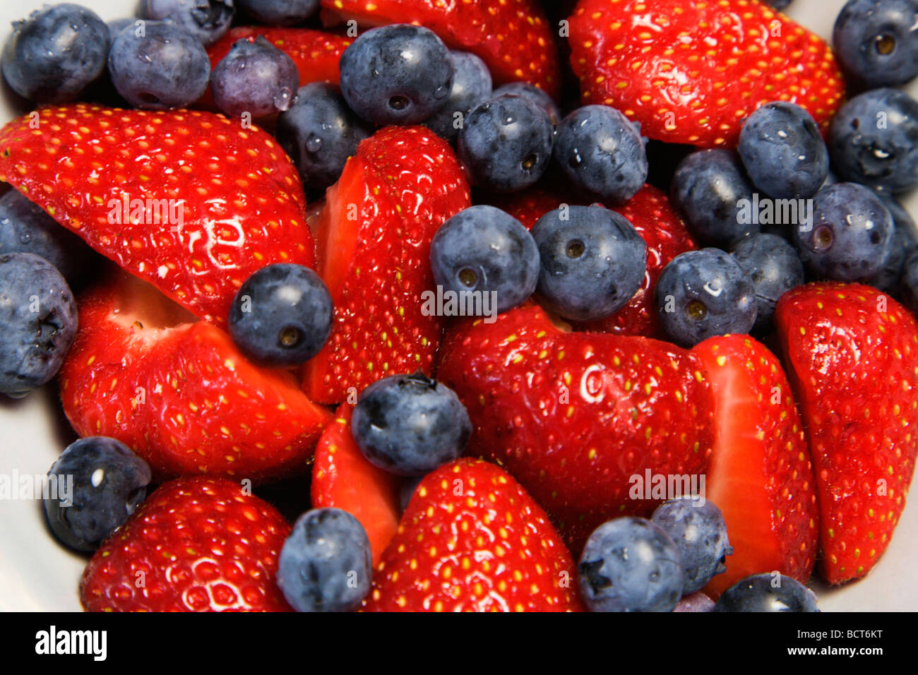 Halbierte Erdbeeren mit Heidelbeeren Stockfoto