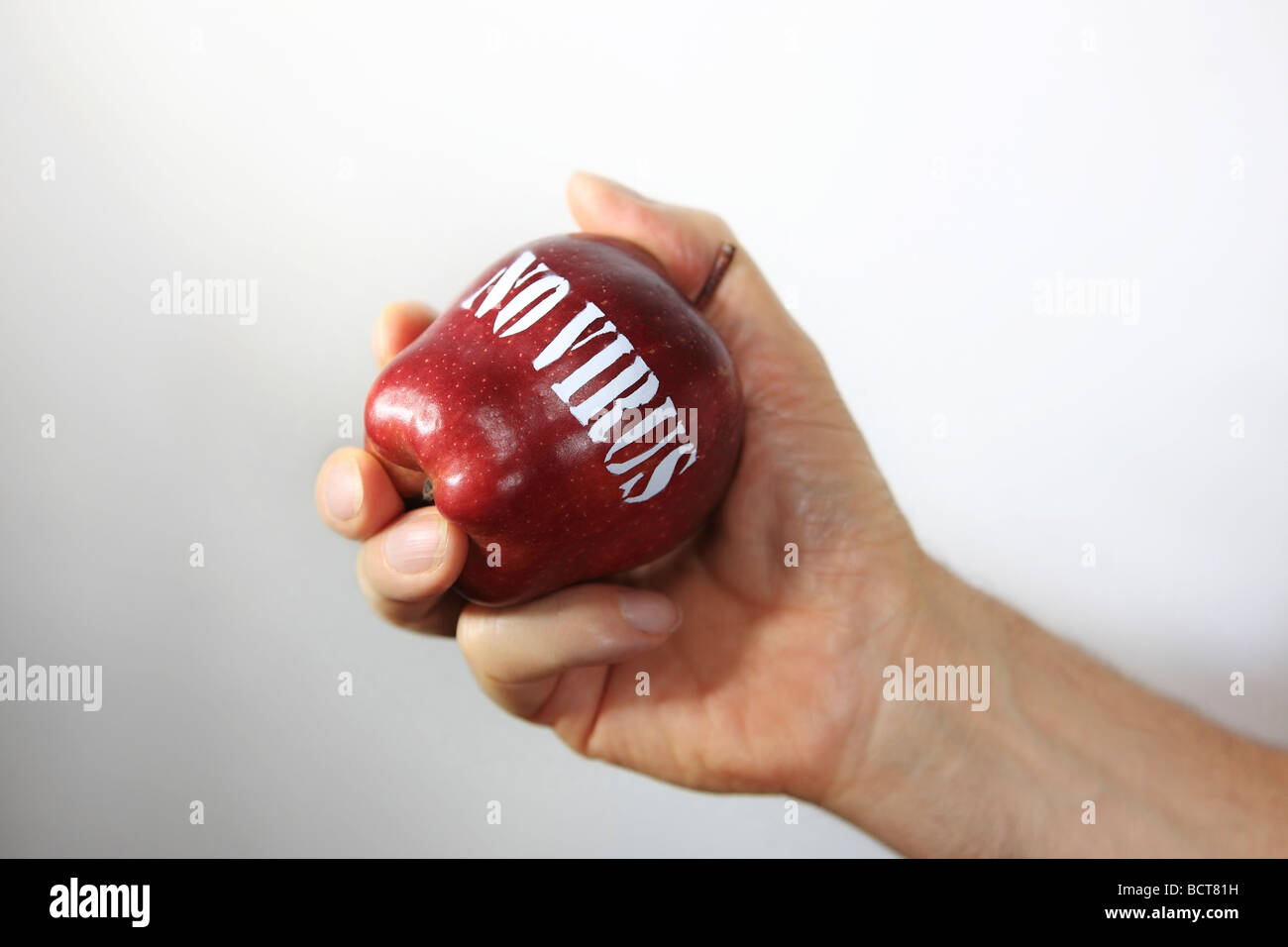 Eine Hand fest halten einen roten Apfel mit einem "kein Virus" Schild Schablonen. Stockfoto