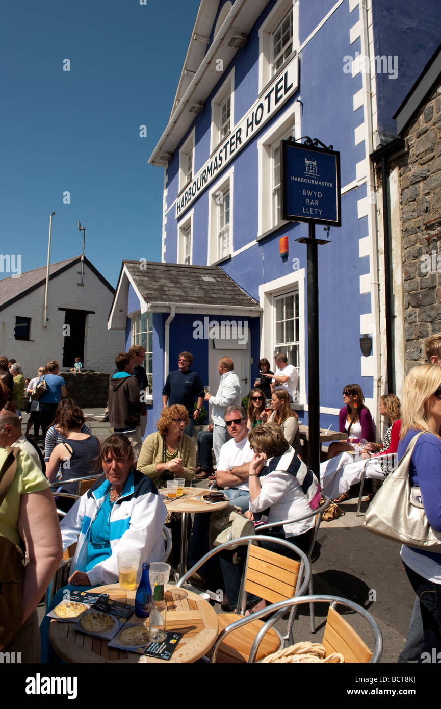 Leute sitzen in der Sonne vor dem Hafenmeister Hotel während Cardigan Bay Seafood Festival 2009 Aberaeron Wales UK Stockfoto