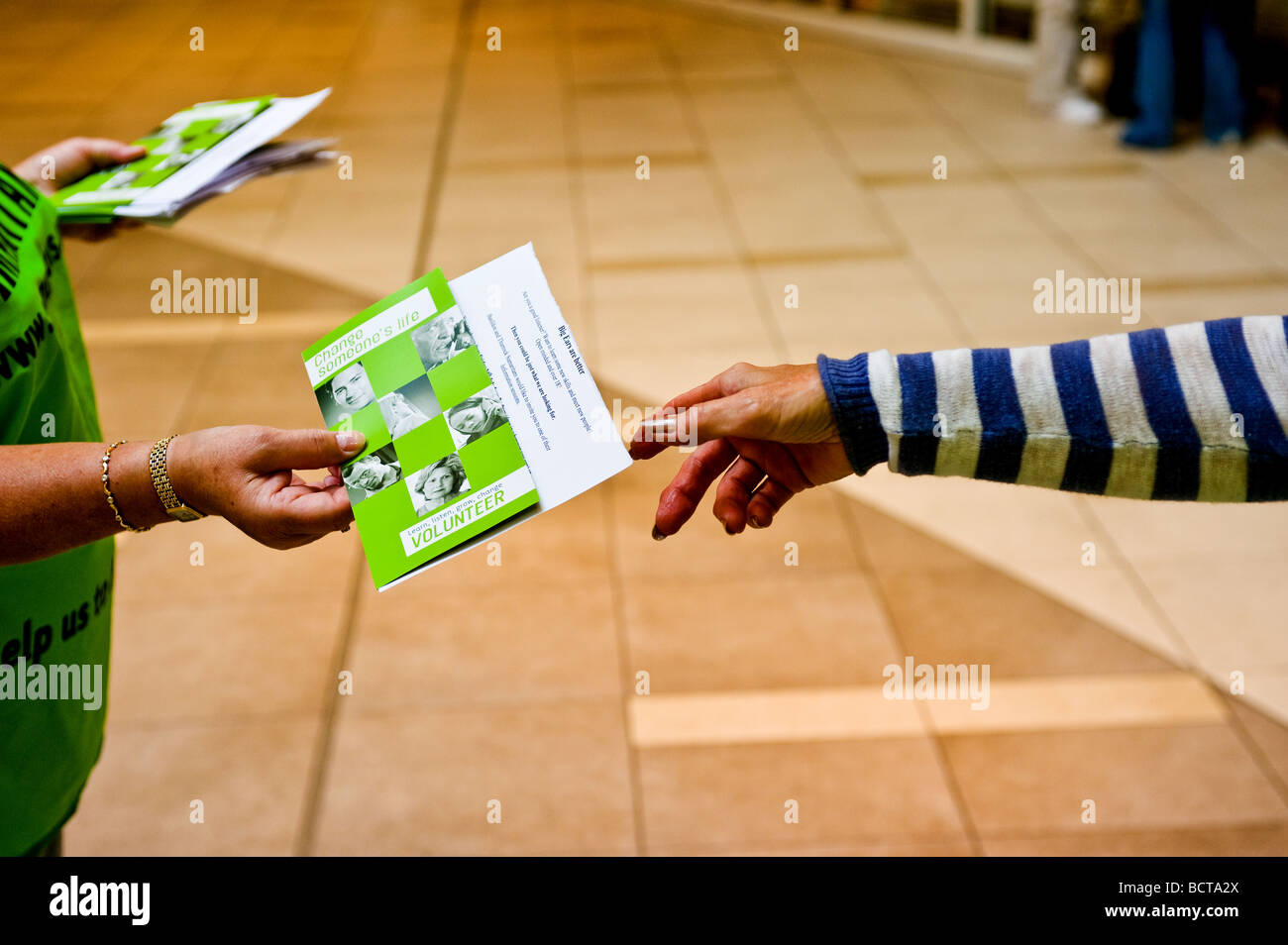 Ein Freiwilliger aus den Samaritern Flugblätter verteilen. Stockfoto