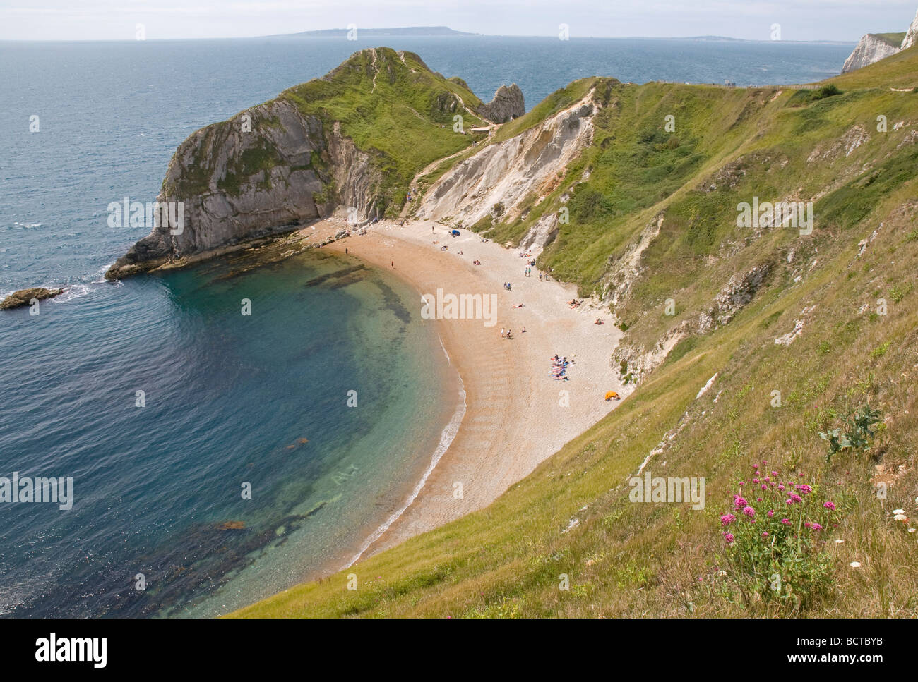 Einladende Strand in St. Oswald Bay in der Nähe von Lulworth Cove, Dorset, mit der Isle of Portland am Horizont. Stockfoto