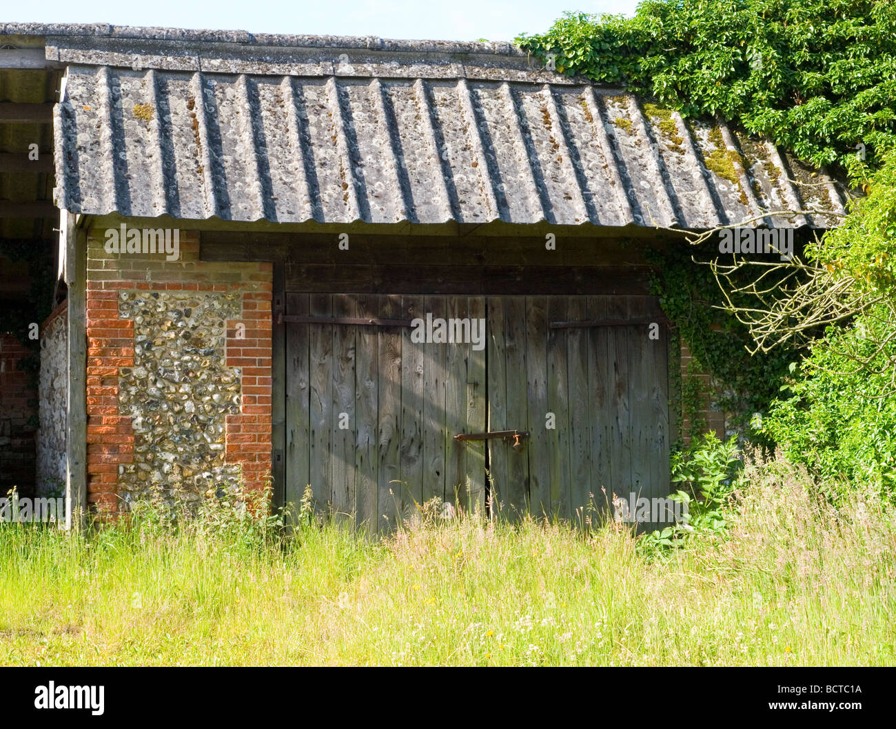 Eine Garage versteckt hinter langen Rasen, in einem Dorf in Norfolk East Anglia England UK Stockfoto