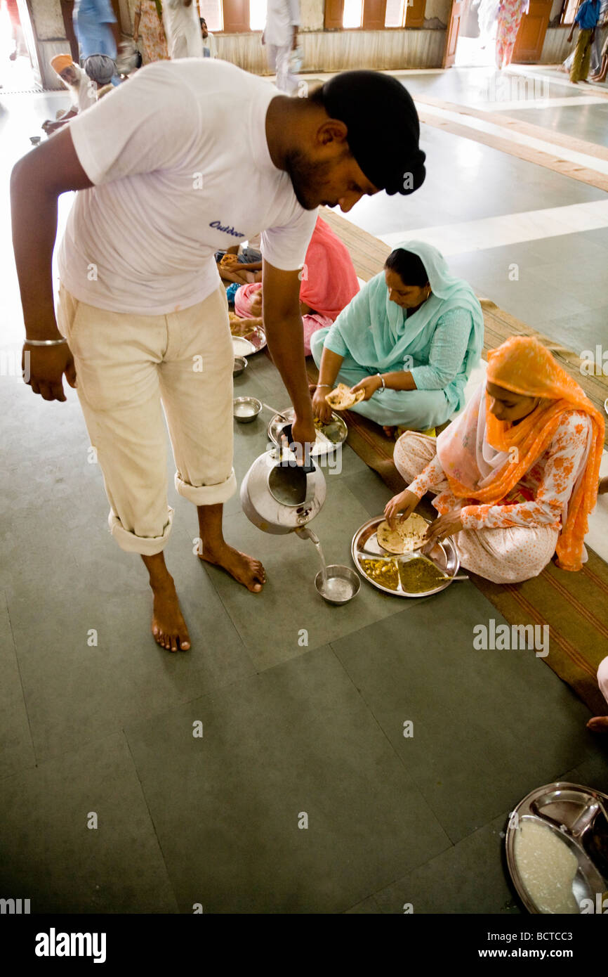 Sikh Mann dient Wasser, Pilger auf eine kostenlose Mahlzeit in der Gemeinschaftsküche, goldenen Tempel (Sri Harmandir Sahib) Amritsar. Indien. Stockfoto