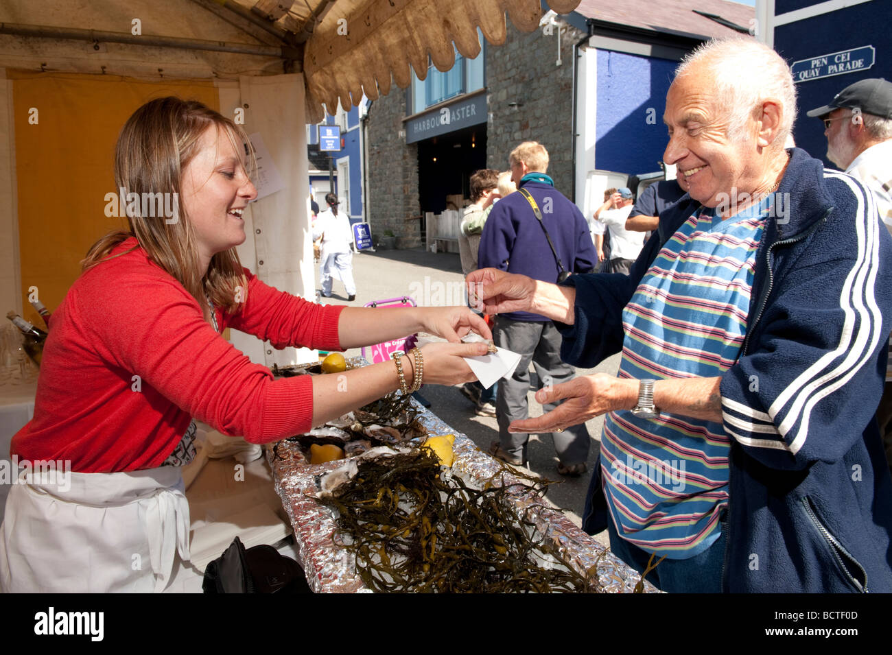 Eine Frau verkauft frische Austern an einen Kunden beim Cardigan Bay Seafood Festival 2009 Aberaeron Ceredigion Wales UK Stockfoto