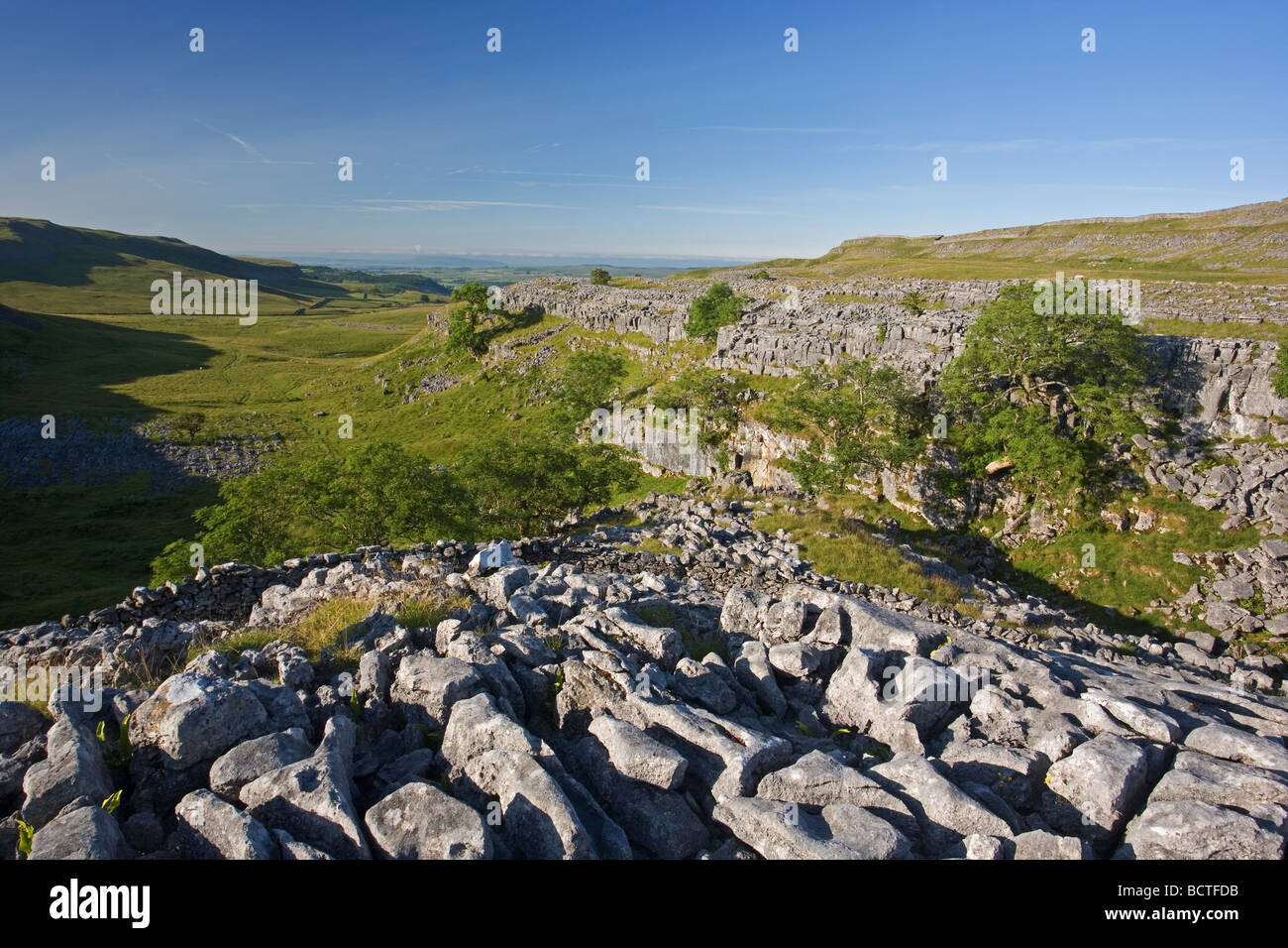 Blick in Richtung Settle aus Kalkstein Pflaster des Sulber Nick in der Moughton Narben Bereich, Crummackdale, Yorkshire Dales, UK Stockfoto