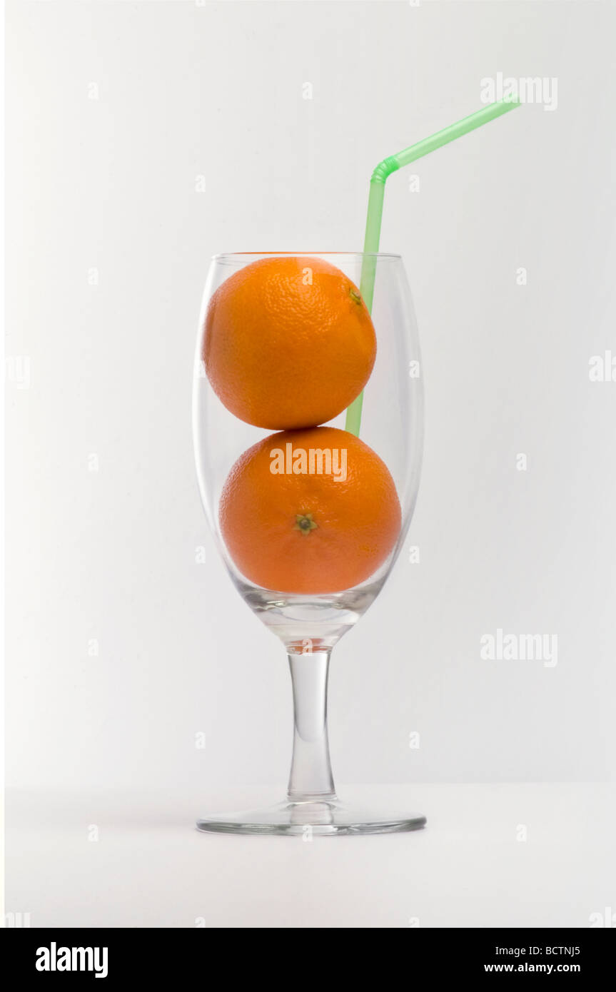 Zwei Orangen mit einen Strohhalm in ein Glas. Stockfoto