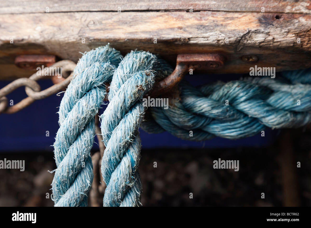 Nahaufnahme eines blauen Seilen an einem rostigen Metall Haken auf einem alten Boot Stockfoto