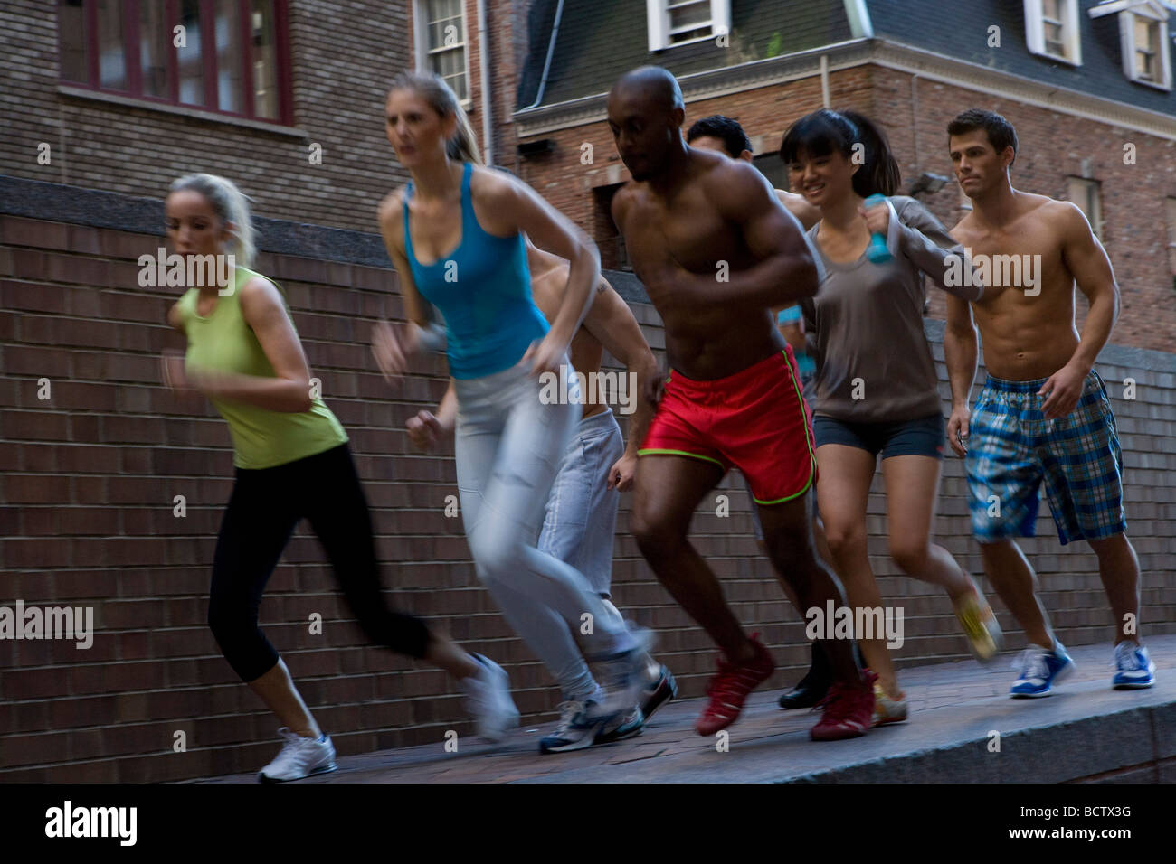 Gruppe von Menschen auf dem Bürgersteig Joggen Stockfoto