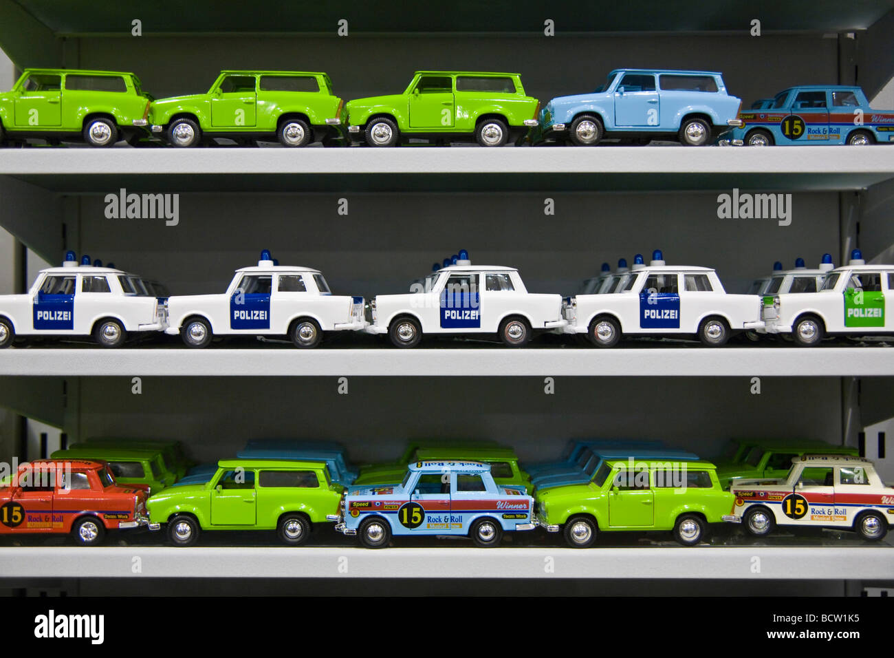 Viele Trabant Miniautos, Trabi-Spielzeug-Autos einschließlich Rennwagen und Polizeiautos auf einem Regal Stockfoto