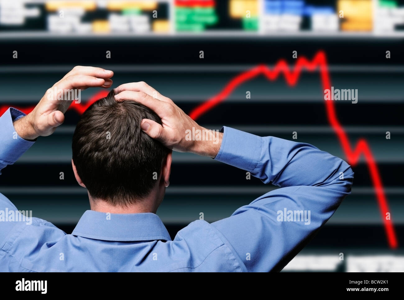 Aktienhändler umklammert seinen Kopf vor einem Bildschirm, einer Börse Crash Stockfoto