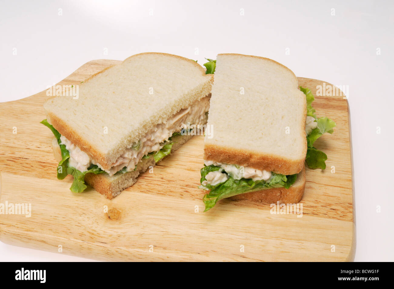 Thunfisch-Mayo Sandwich auf Weißbrot mit Salat auf Holz Schneidebrett ...