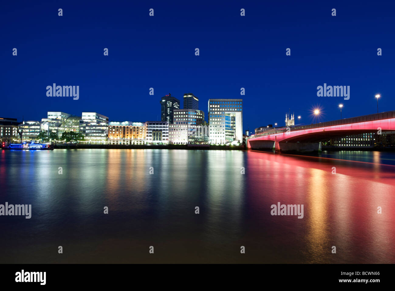 London Bridge Gebäude am südlichen Ufer und der Themse bei Nacht. Stockfoto