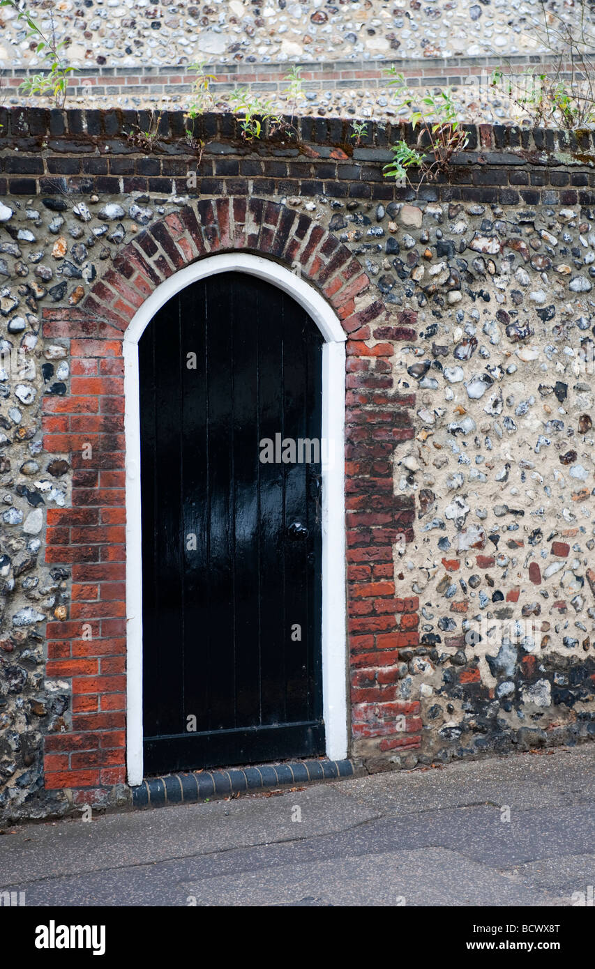 Einem schwarzen Tor, Ziegel und Stein Wand eingelassen. Stockfoto