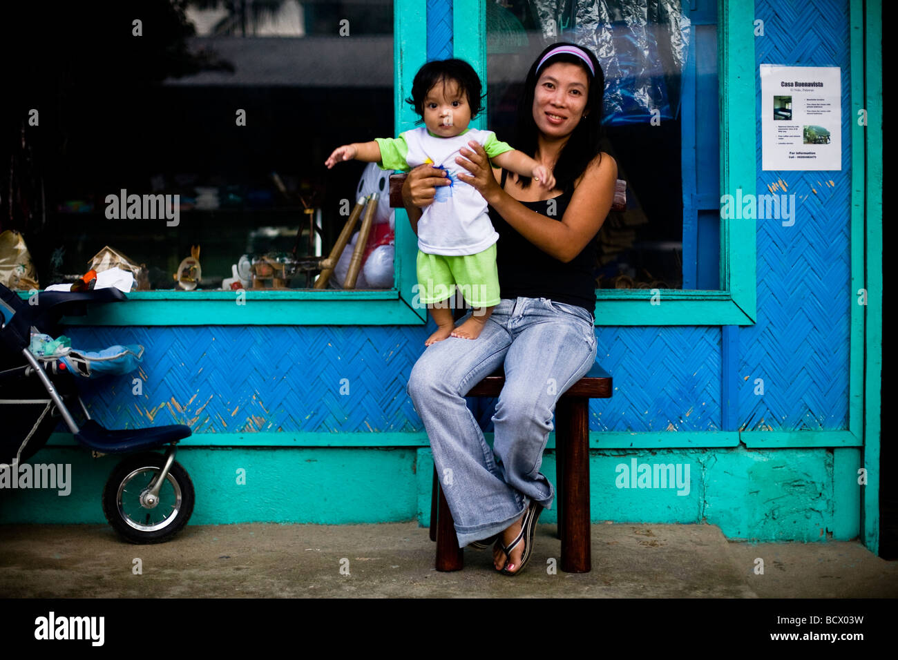 Mutter und Kind sitzen vor einem Geschäft in El Nido auf der Insel Palawan auf den Philippinen Stockfoto