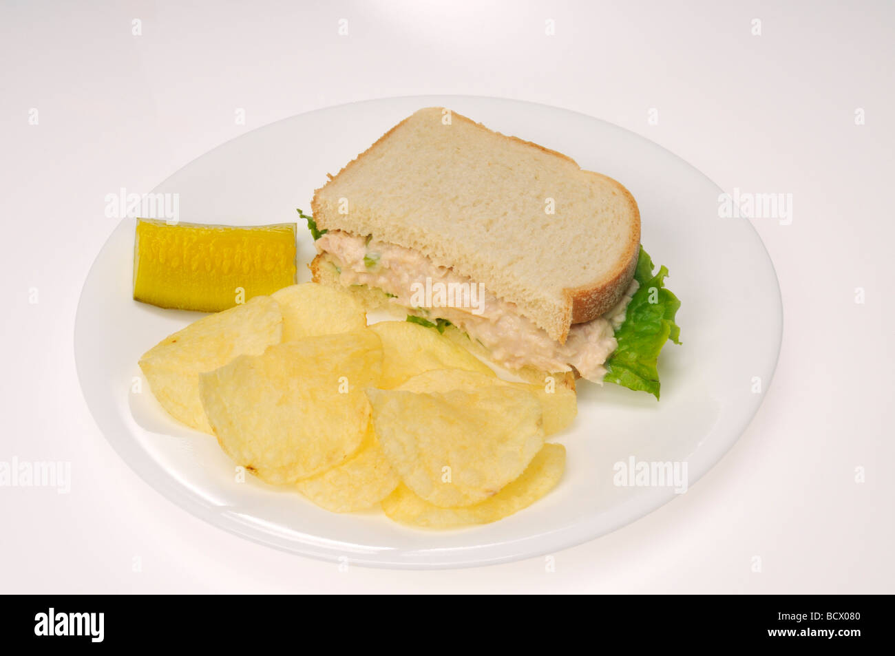 Thunfisch-Mayo-Sandwich mit Salat auf Weißbrot mit Gurke und Kartoffelchips Stockfoto