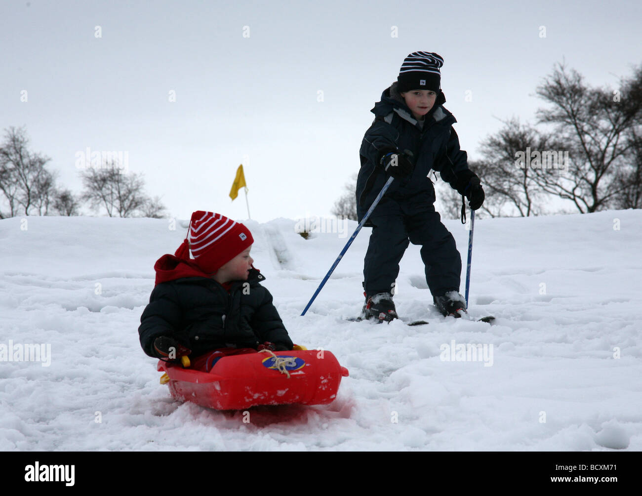 Kinder spielen im Schnee auf dem Golfplatz Newtonmore Schottland Stockfoto