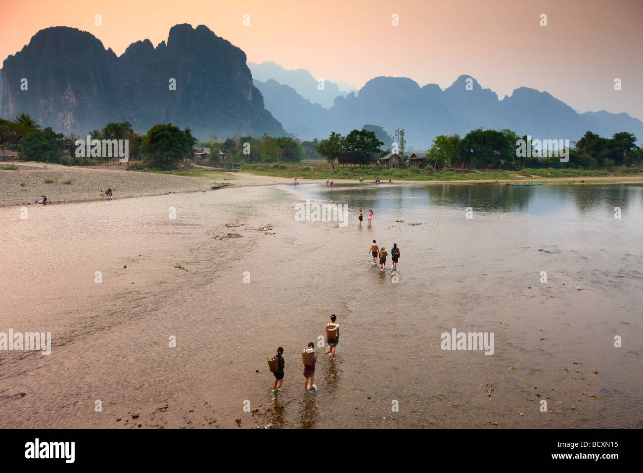 Frauen waten Nam Song River in Vang Vieng, Laos Stockfoto