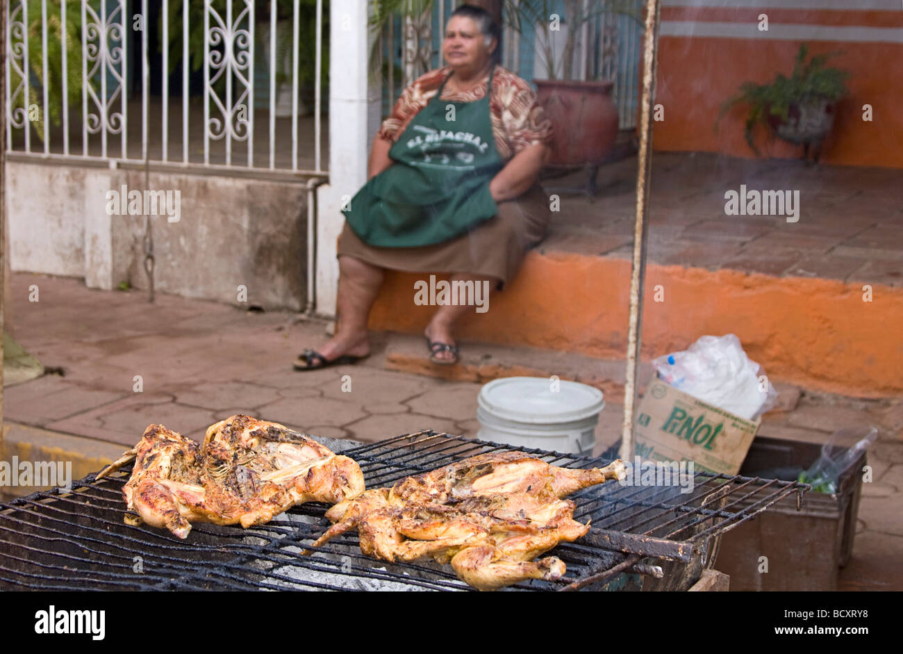 Frau sitzt am vorderen Schritt eines Hauses während kocht sie Hühner, die sie in El Quelite, Mexiko zu verkaufen Stockfoto