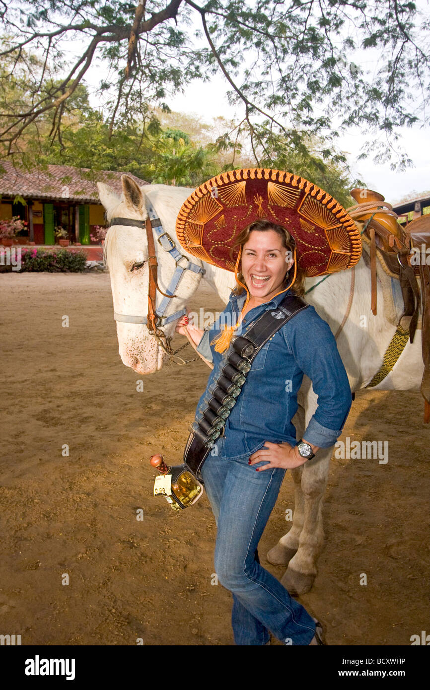 Tequila Bandita posiert Mädchen mit Pferd und Aufnahmen von Tequila in einer Tequilafabrik nördlich von Mazatlan, Mexiko. Stockfoto
