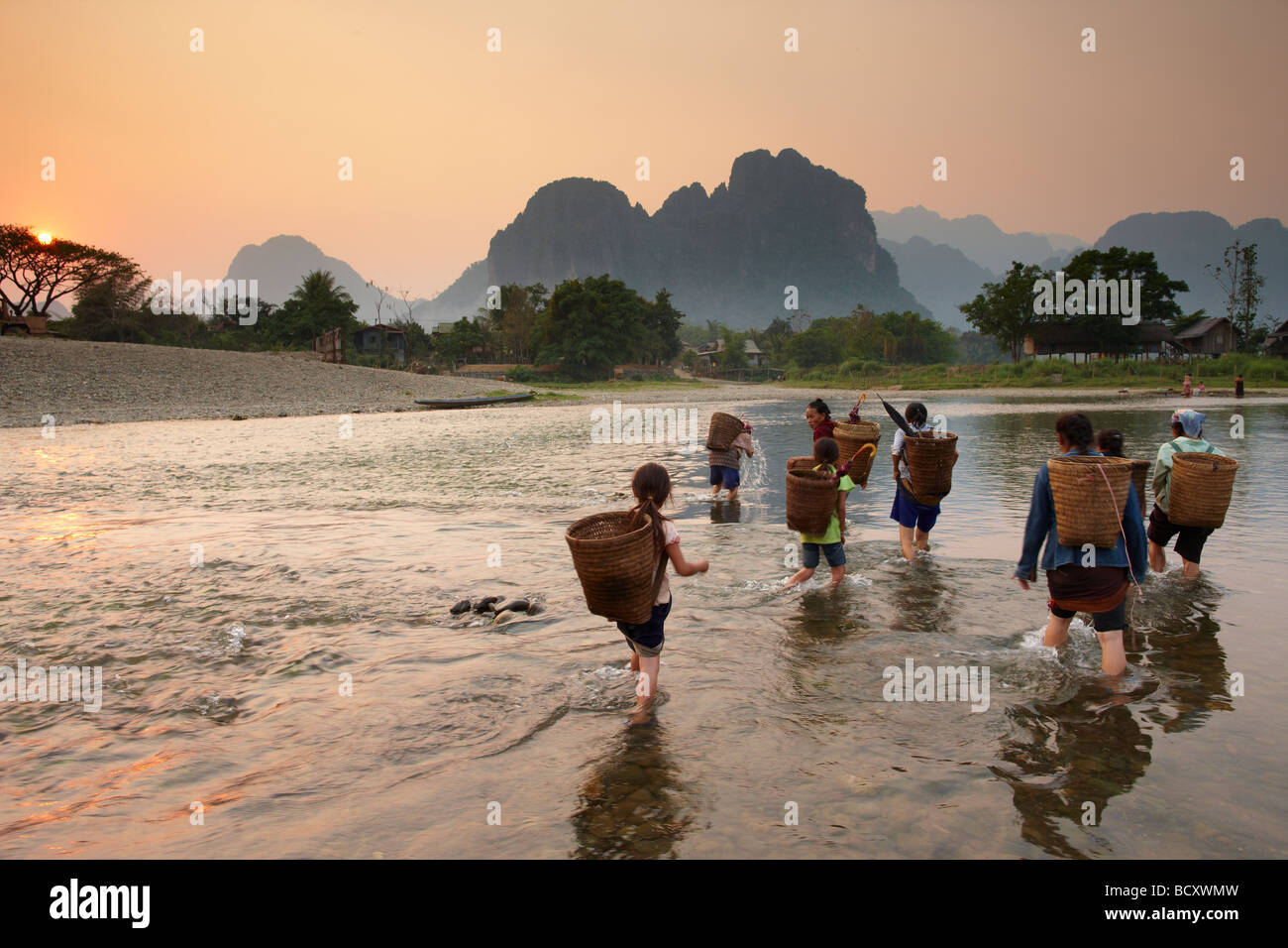 Frauen und Mädchen fording Nam Song River in Vang Vieng, Laos Stockfoto
