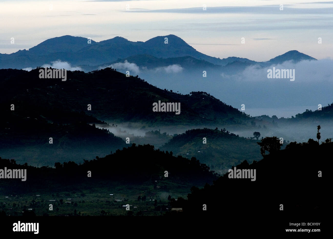Ineinander greifende Täler und Nebel am frühen Morgen in der Nähe der Grenze der Demokratischen Republik Kongo. Stockfoto