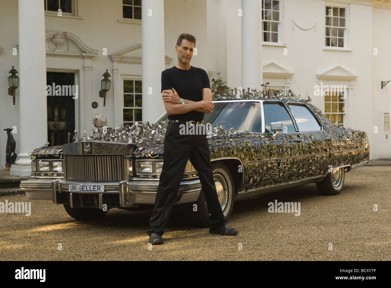URI Geller zu Hause außerhalb seines Herrenhauses. Sein Cadillac ist mit gebogenen Löffeln bedeckt. URI GELLER Kfz-Kennzeichen. Berkshire UK 2008 2000er HOMER SYKES. Stockfoto