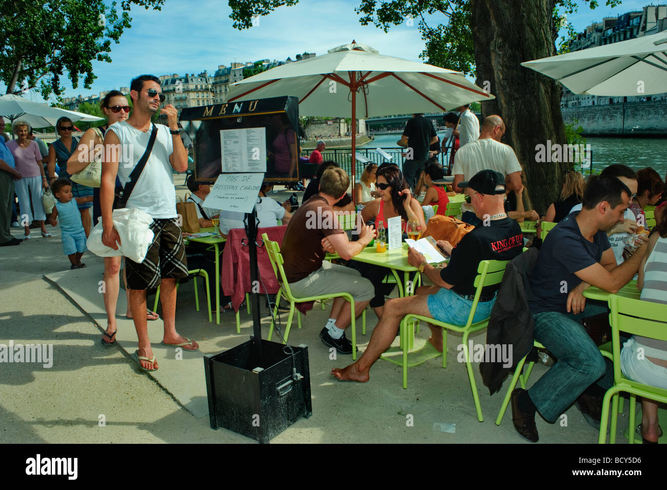 Paris Frankreich, Public People Sharing Mahlzeiten im French Bistro Restaurant an der seine Plage an den Tischen „Paris Plage“ Regenschirme Stockfoto