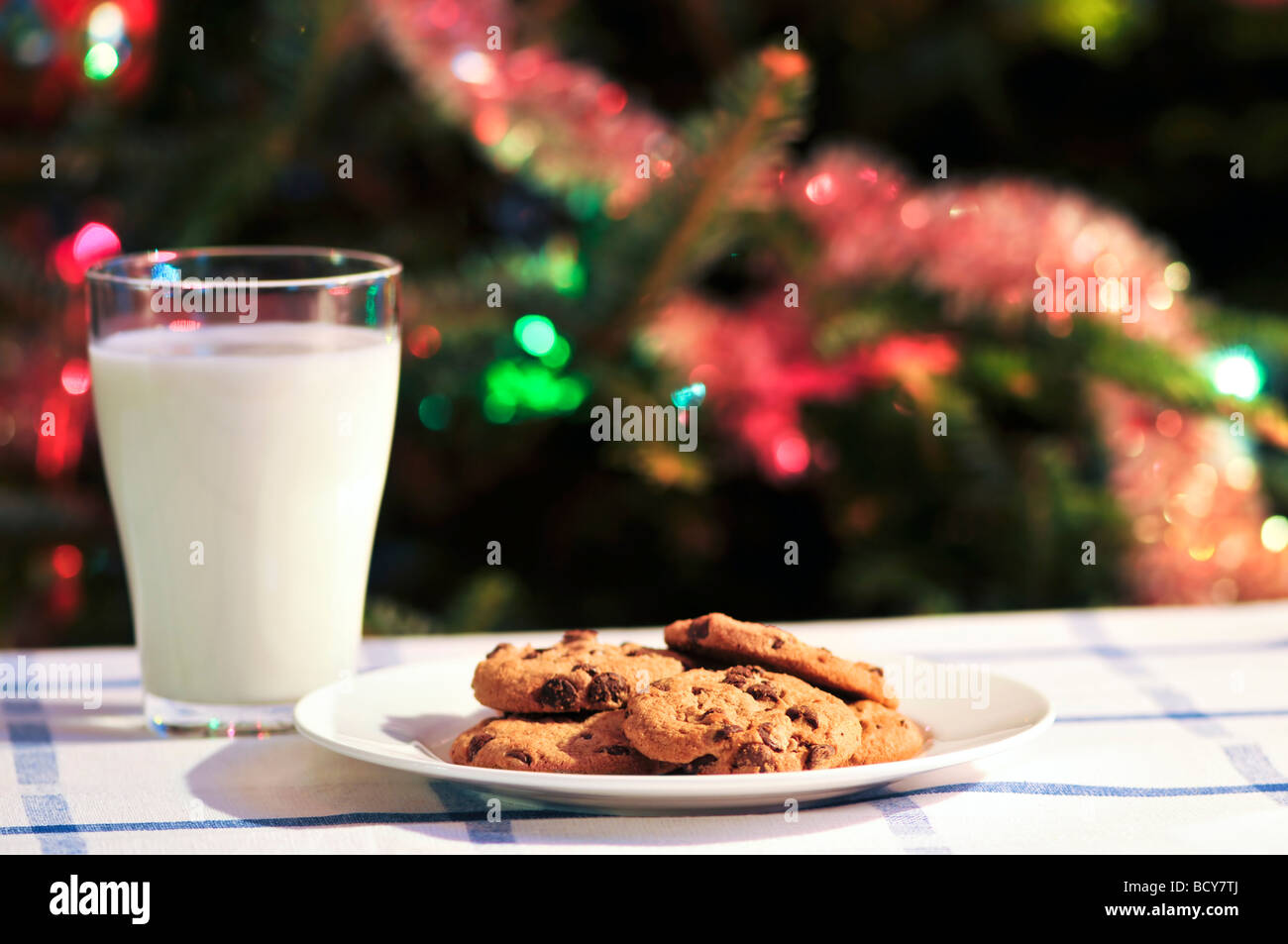 Teller mit Plätzchen und Glas Milch in der Nähe von Christmas tree Stockfoto