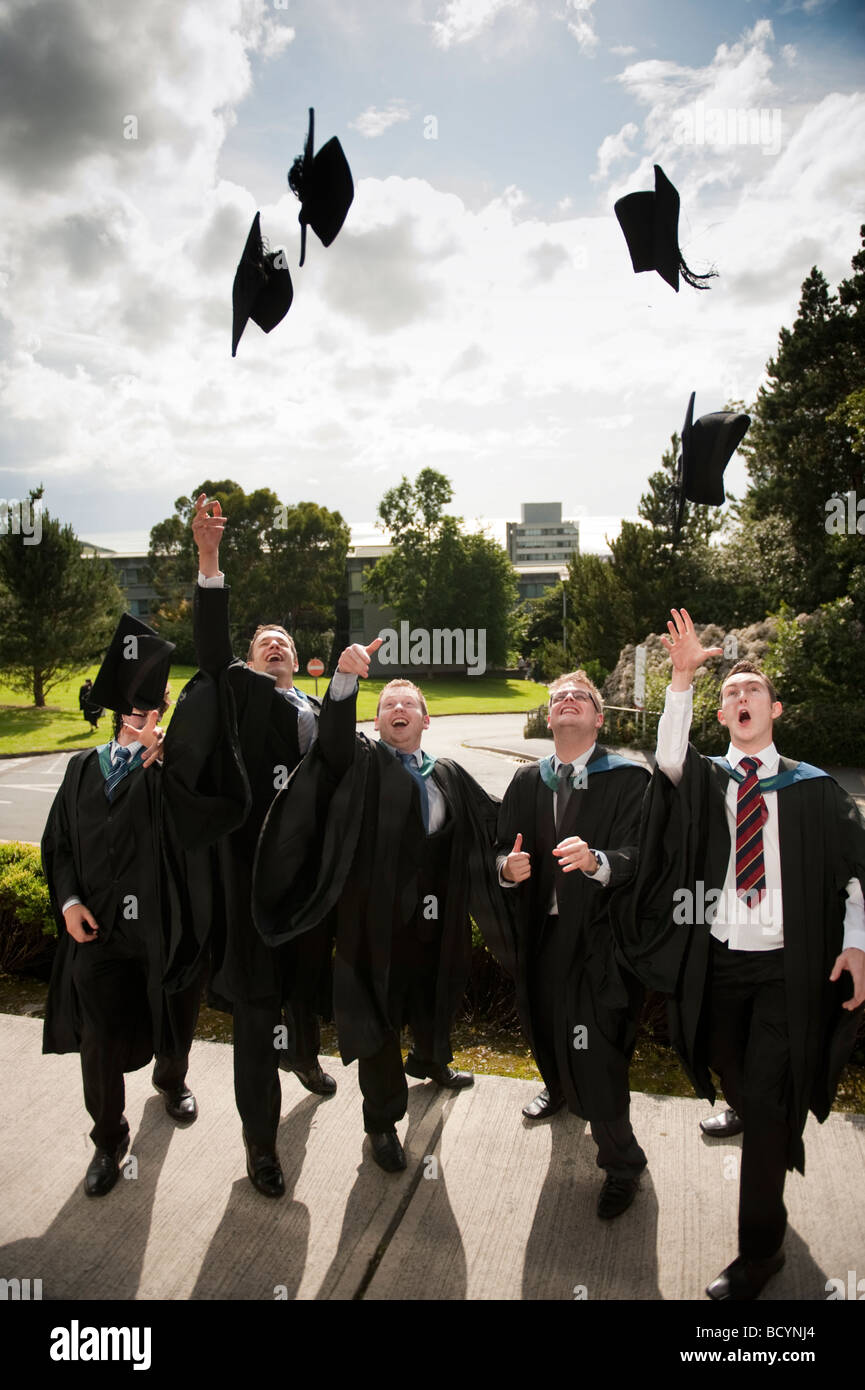 5 fünf männlichen Aberystwyth University Studenten Abschlusstag werfen ihre Mützen in die Luft in der Feier Wales UK Stockfoto